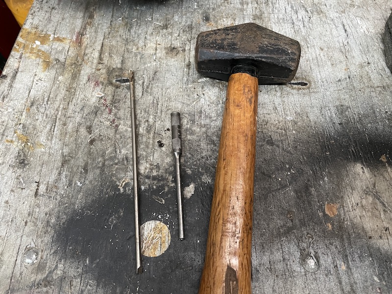 Hammer, punch, and drill bit used to remove an outboard jet intake grate retaining rod