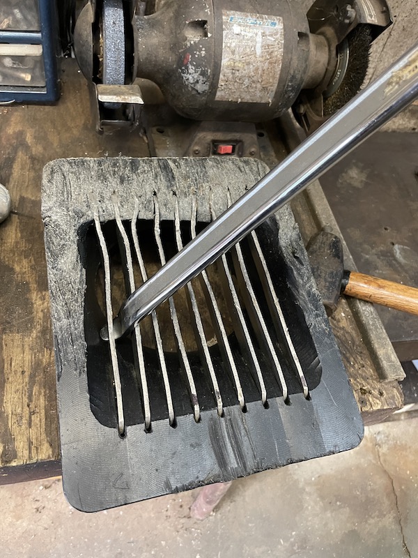 Pry bar lifting an outboard jet intake grate bar out of the intake