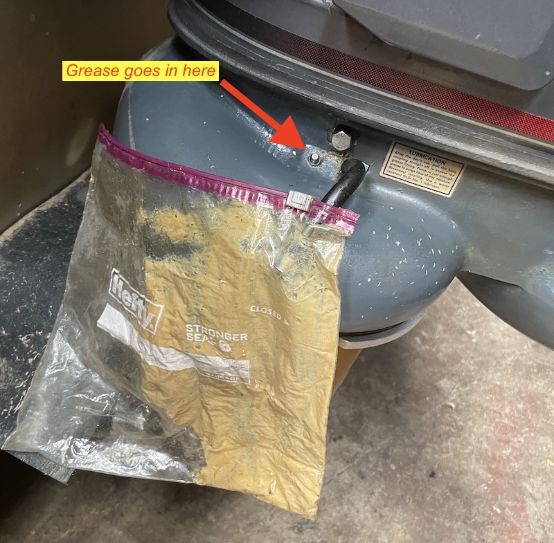 Clear bag catching old grease and water purged from an outboard jet vent hose