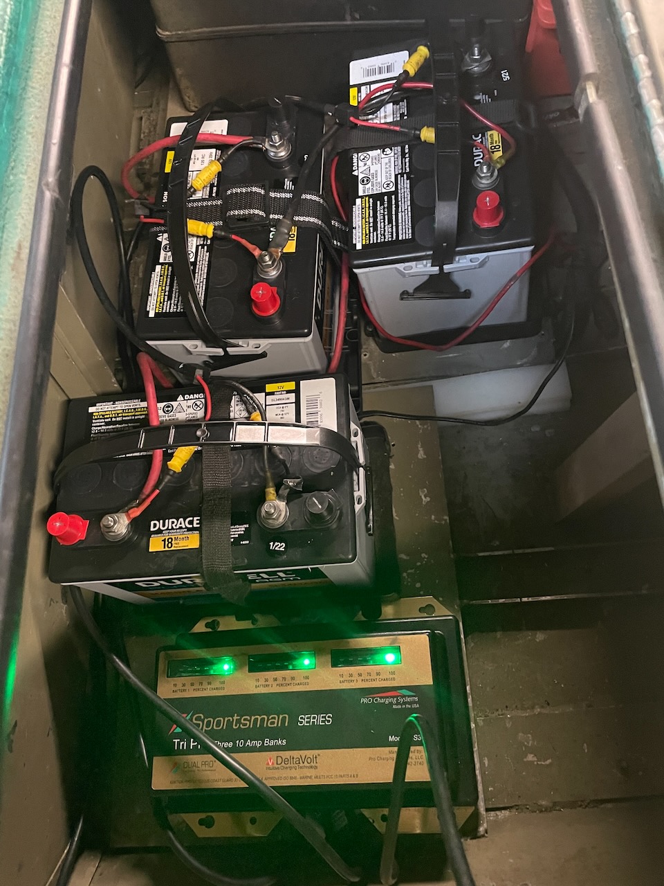 Three Duracell AGM trolling-motor batteries and a Dual Pro charger installed in an outboard jet boat